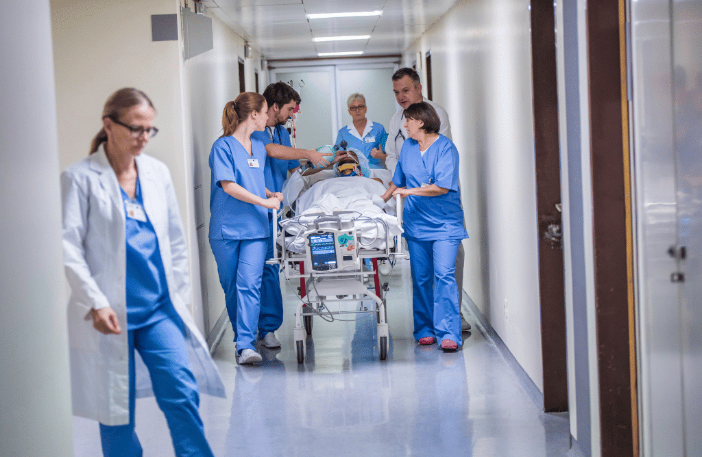 hospital staff carrying a patient in the hospital hall way