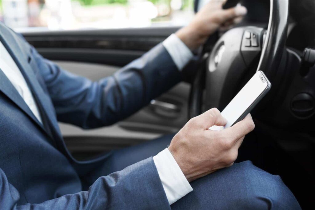 Man pressing phone while driving