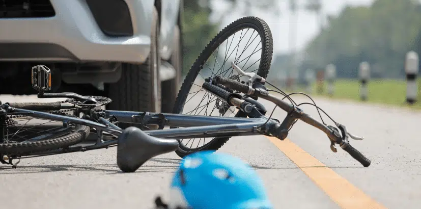 A fallen bicycle hit by a car