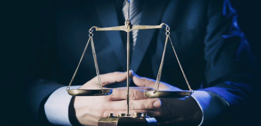 A lawyer sitting behind a scale